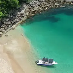Lancha na beira de praia de água transparente