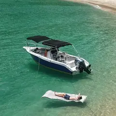 Lancha ancorada em praia de água transparente