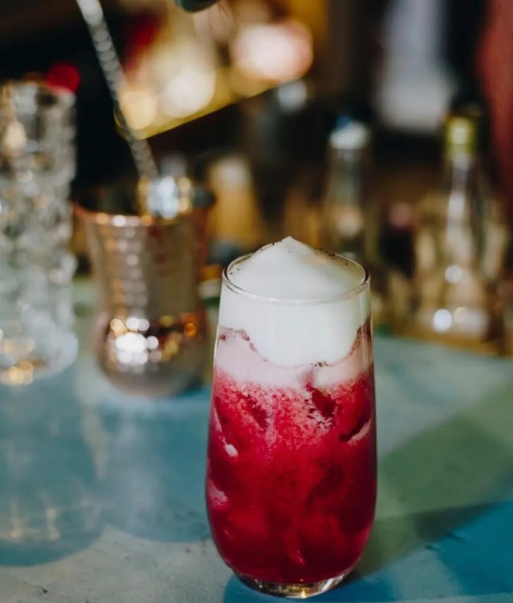 Drink vermelho com espuma servido no Estaleiro Bar