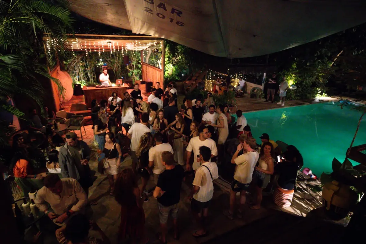 DJ tocando ao lado da piscina no Floresta Bar