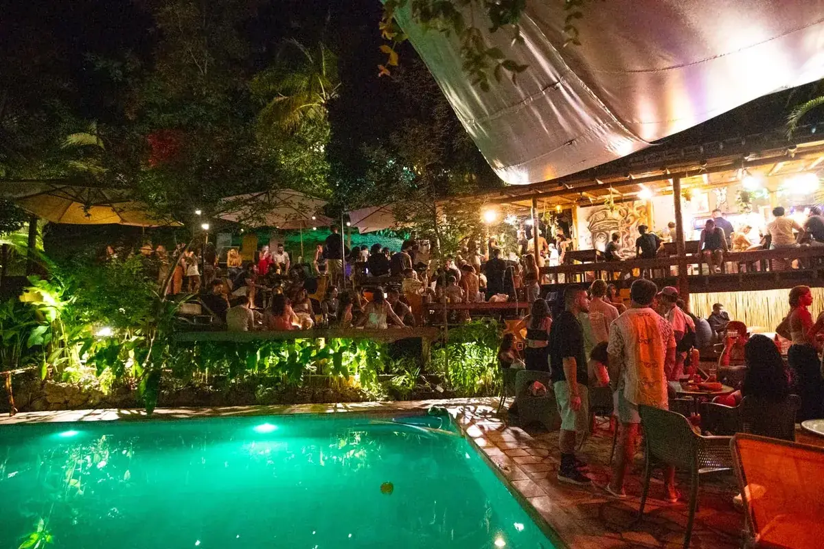 Festa à noite ao redor da piscina do Floresta Bar, no Hostel da Vila