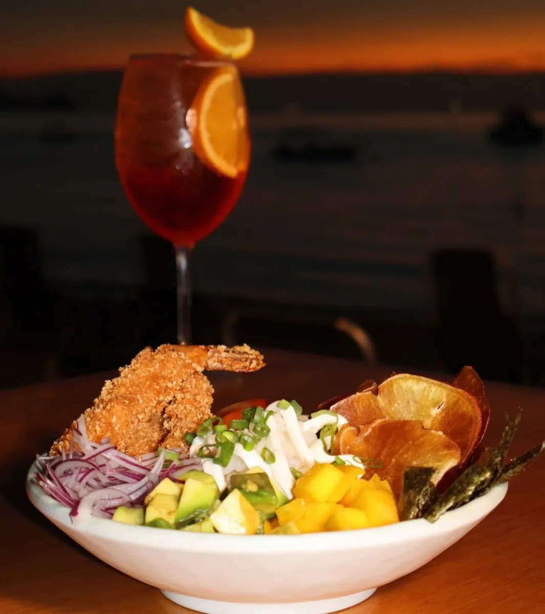 Poke com camarão empanado e drink ao pôr do sol no Tullum