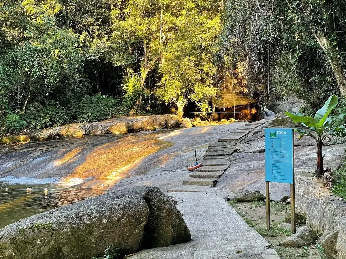 Escorregador natural e escadaria da Cachoeira da Toca, com placa de orientação