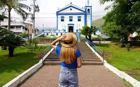 Escadaria e fachada azul e branca da Igreja Matriz Nossa Senhora D’Ajuda, na Vila