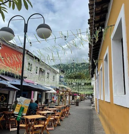 Rua da Vila decorada com bandeirinhas e mesas ao ar livre