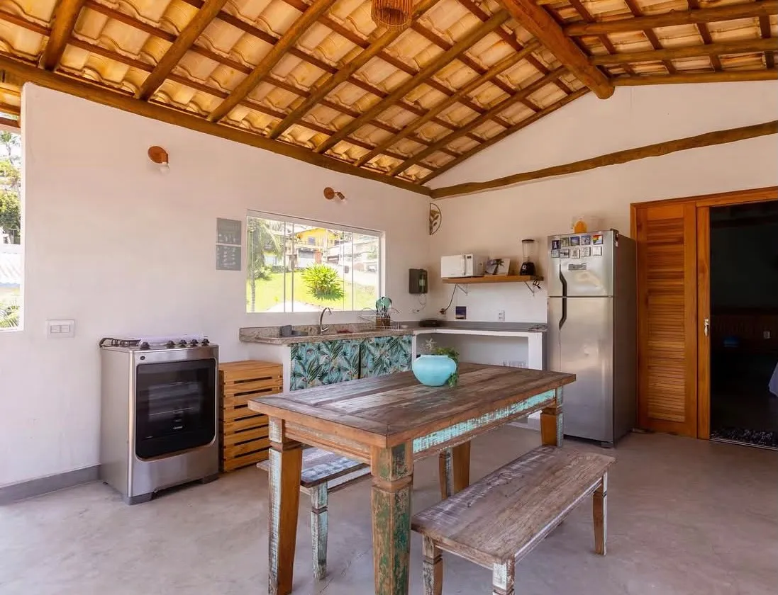 Cozinha compartilhada com mesa de madeira, na Casa Maembippe