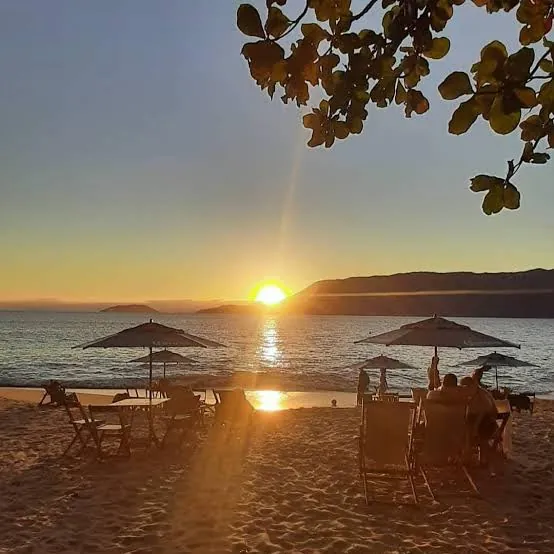 Pôr do sol na Praia do Curral com guarda-sóis e cadeiras na areia