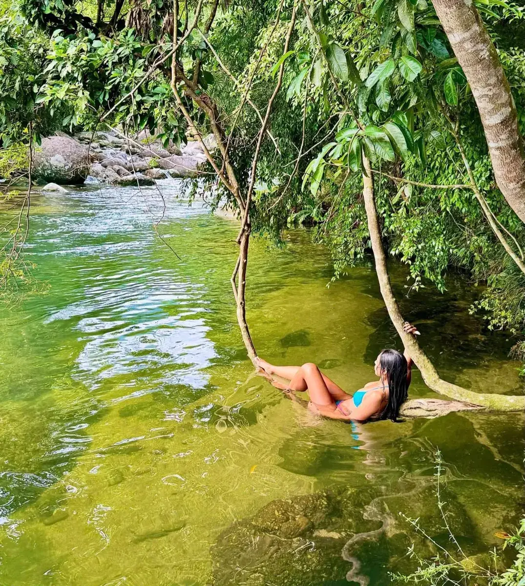Visitante relaxando num galho sobre o poço da cachoeira