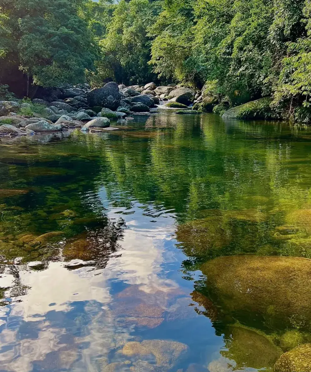 Poço de água cristalina refletindo o céu na Cachoeira do Poço Fundo