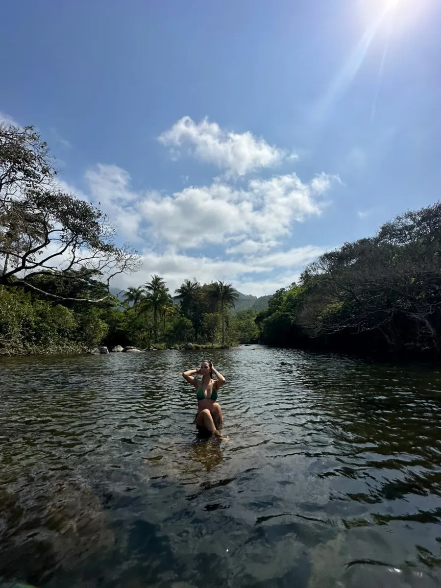 Visitante sentada nas águas calmas do Rio Nema
