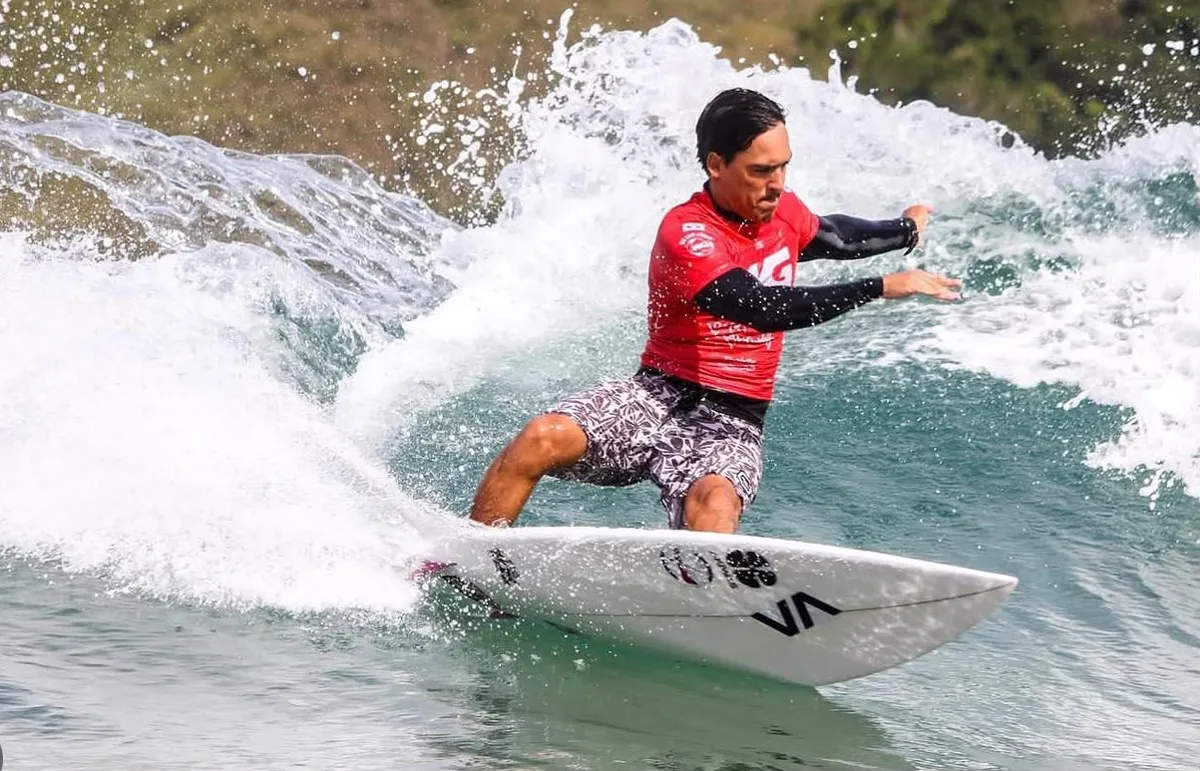 Surfista de lycra vermelha manobrando no Bonete