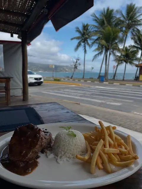 Prato feito servido no Restaurante Luz do Mar, com o mar ao fundo